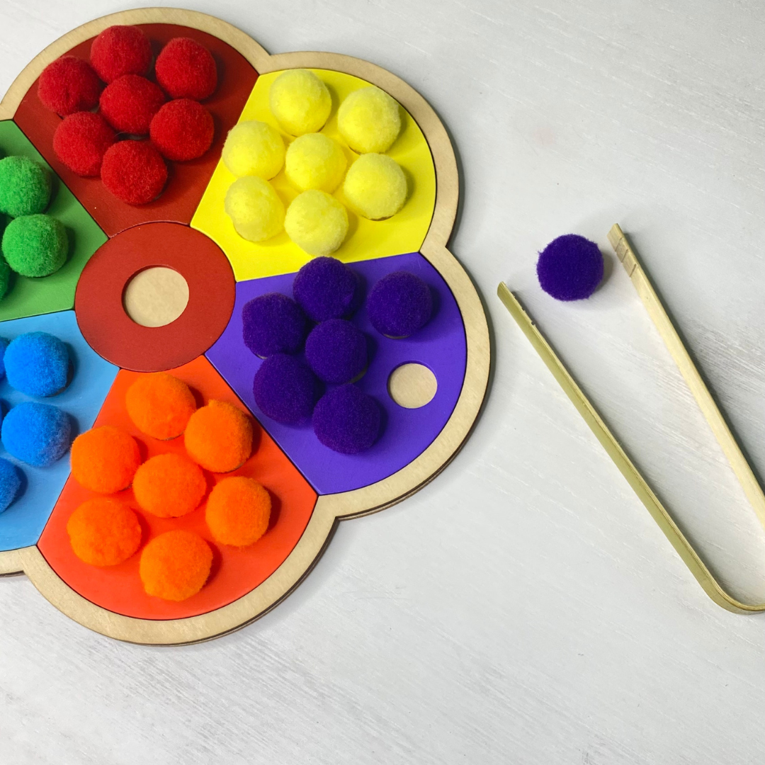 Wooden flower puzzle with matching pom poms! Practice pre-writing skills and exercise hand muscles with the tongs and pom poms!