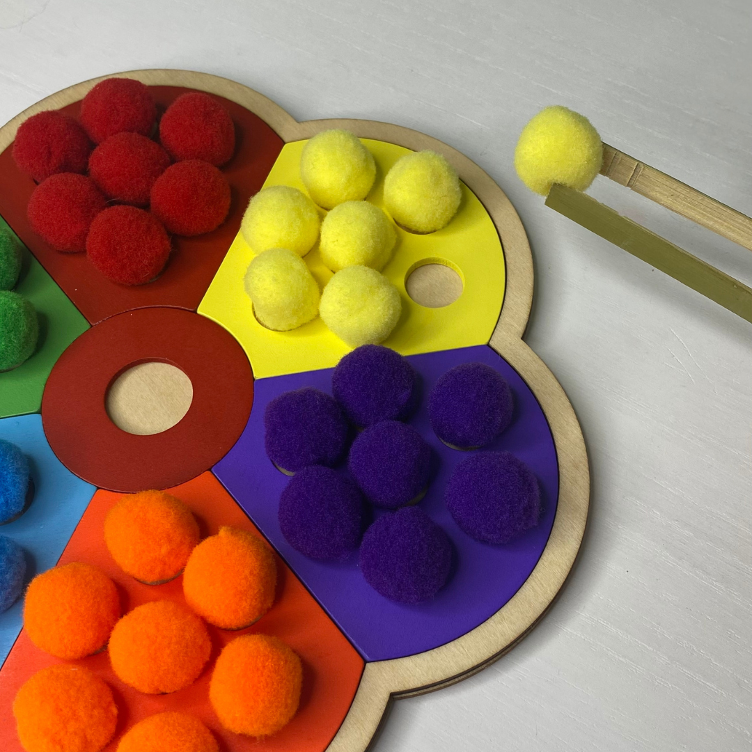Pom Pom matching, wooden puzzle! Match up the colored pom poms with the matching color and pick up the pom poms with the included tongs!