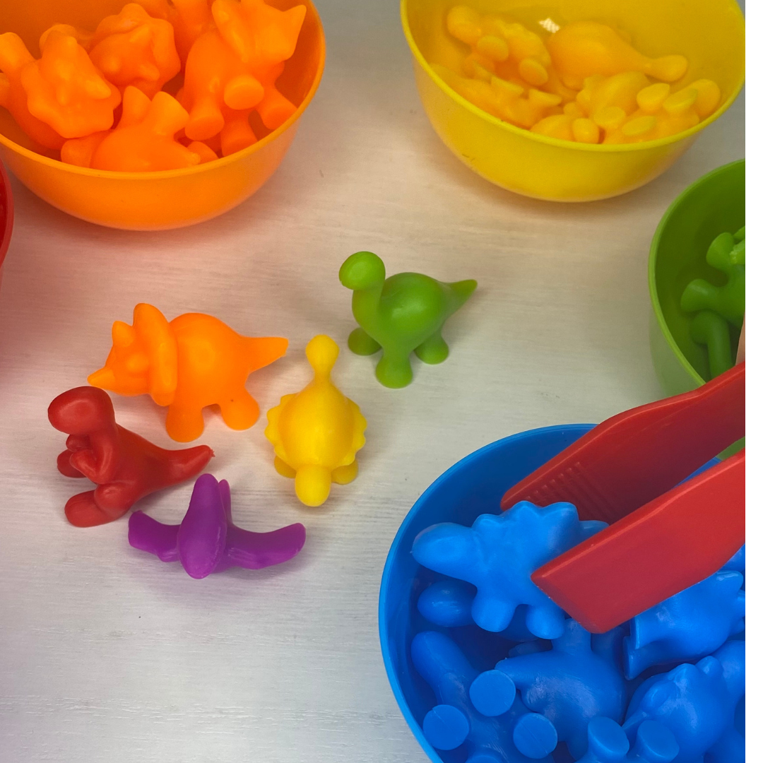 Use tongs to help count/sort our rainbow dinosaurs to help improve fine motor skills!